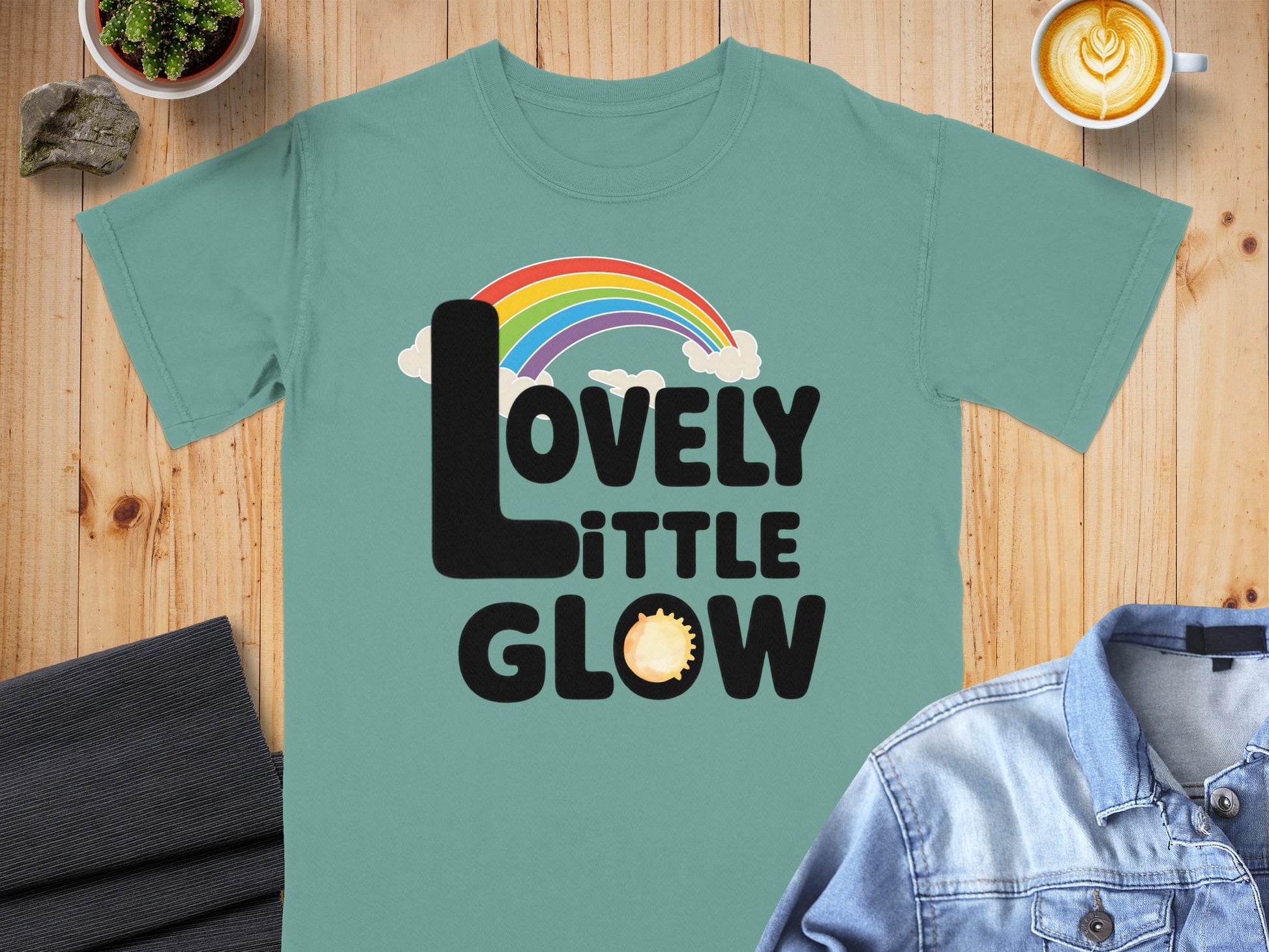 LOVELY LITTLE GLOW text with rainbow and sun graphic.