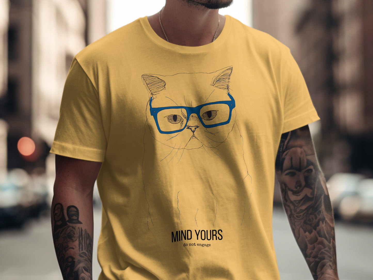 Yellow t-shirt with a sketch of a cat wearing glasses and text "Mind Yours do not engage".