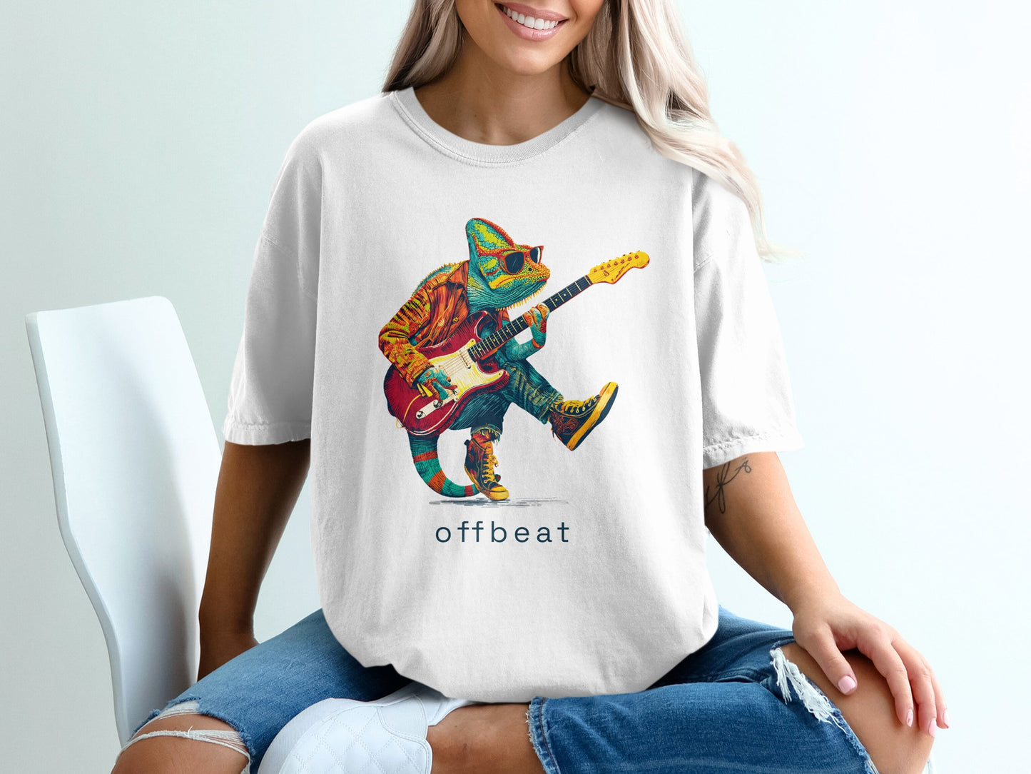Chameleon in sunglasses plays a guitar on a white t-shirt.