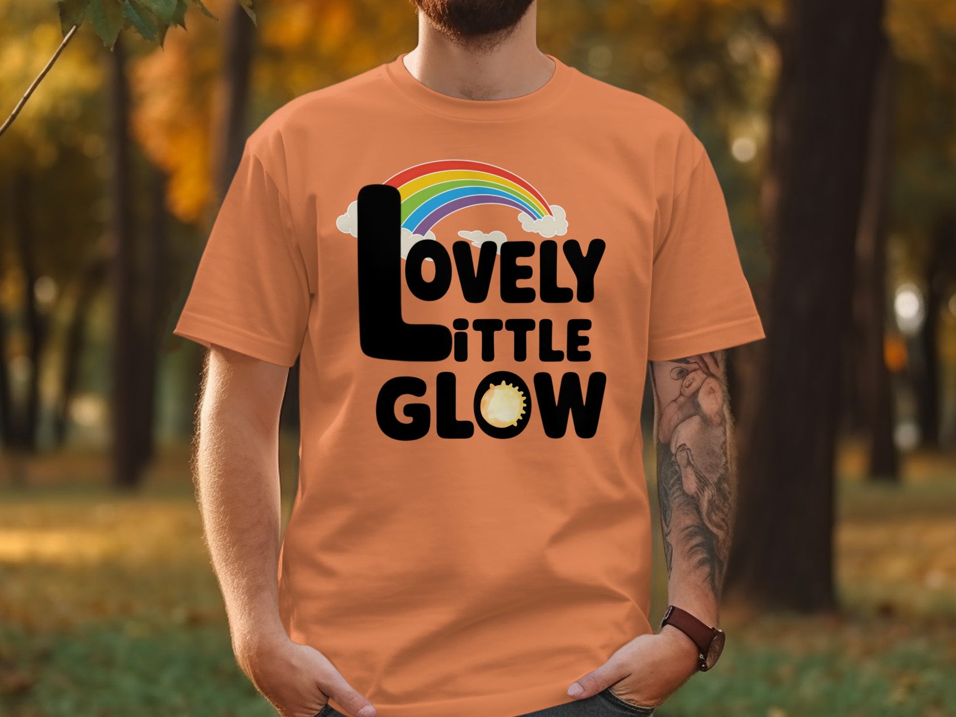 Orange t-shirt with rainbow and "Lovely Little Glow" text.