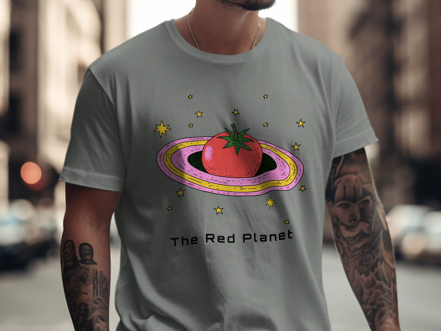 Gray t-shirt with a cartoon tomato on a pink and yellow ringed planet.