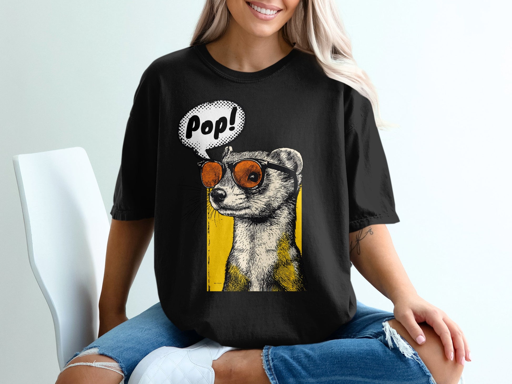 Black t-shirt with a graphic of a ferret wearing sunglasses and a speech bubble saying "Pop!"