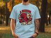 Octopus holding cake with "A Sucker For Cake" text on light blue t-shirt.