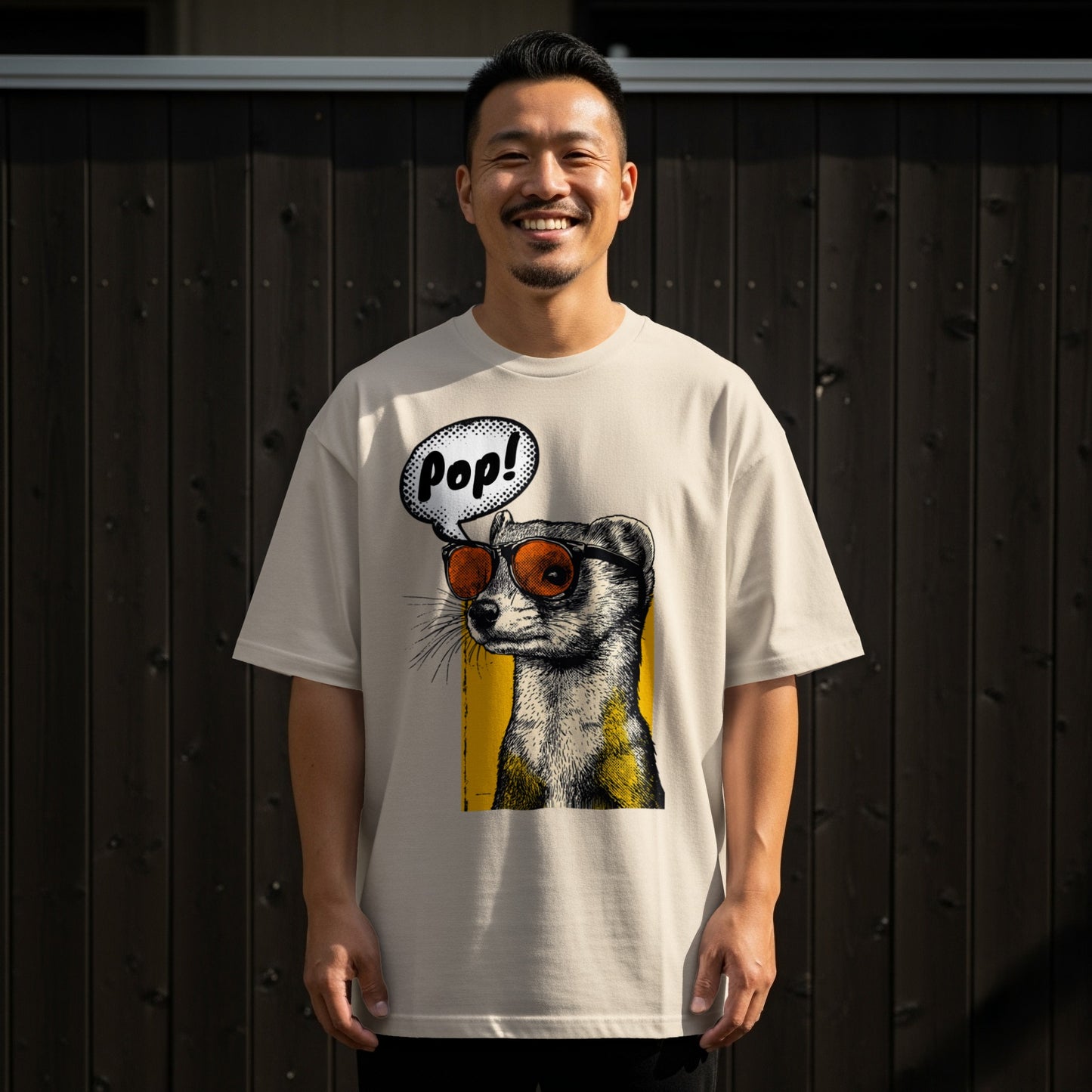 Man wearing a beige t-shirt featuring a ferret wearing sunglasses and a "Pop!" speech bubble.