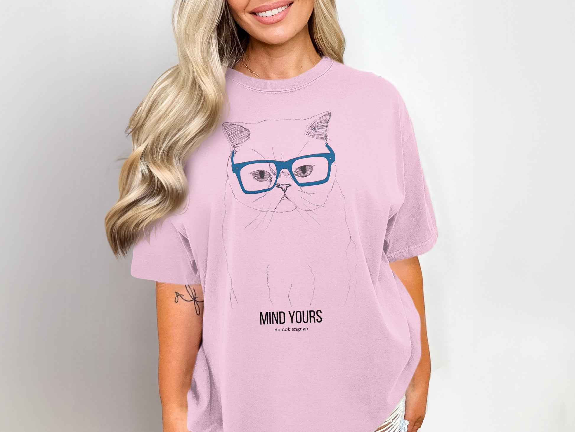 Pink t-shirt with a cat wearing glasses and the text "MIND YOURS do not engage".