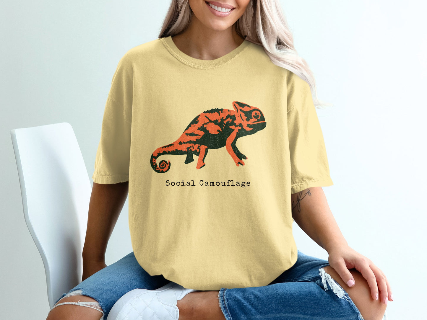Yellow t-shirt with a black and orange chameleon and "Social Camouflage" text.