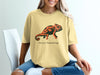 Yellow t-shirt with a black and orange chameleon and "Social Camouflage" text.