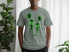 Gray t-shirt with green alien graphic holding balloons.