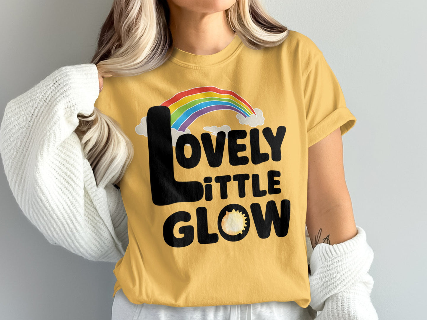 Yellow t-shirt with "Lovely Little Glow" and rainbow design.