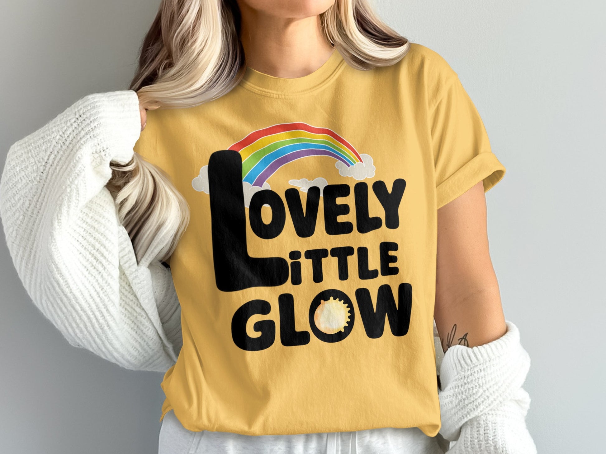 Yellow t-shirt with "Lovely Little Glow" and rainbow design.