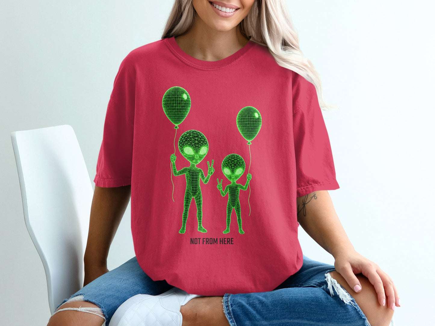 Red t-shirt with neon green alien outlines holding balloons.