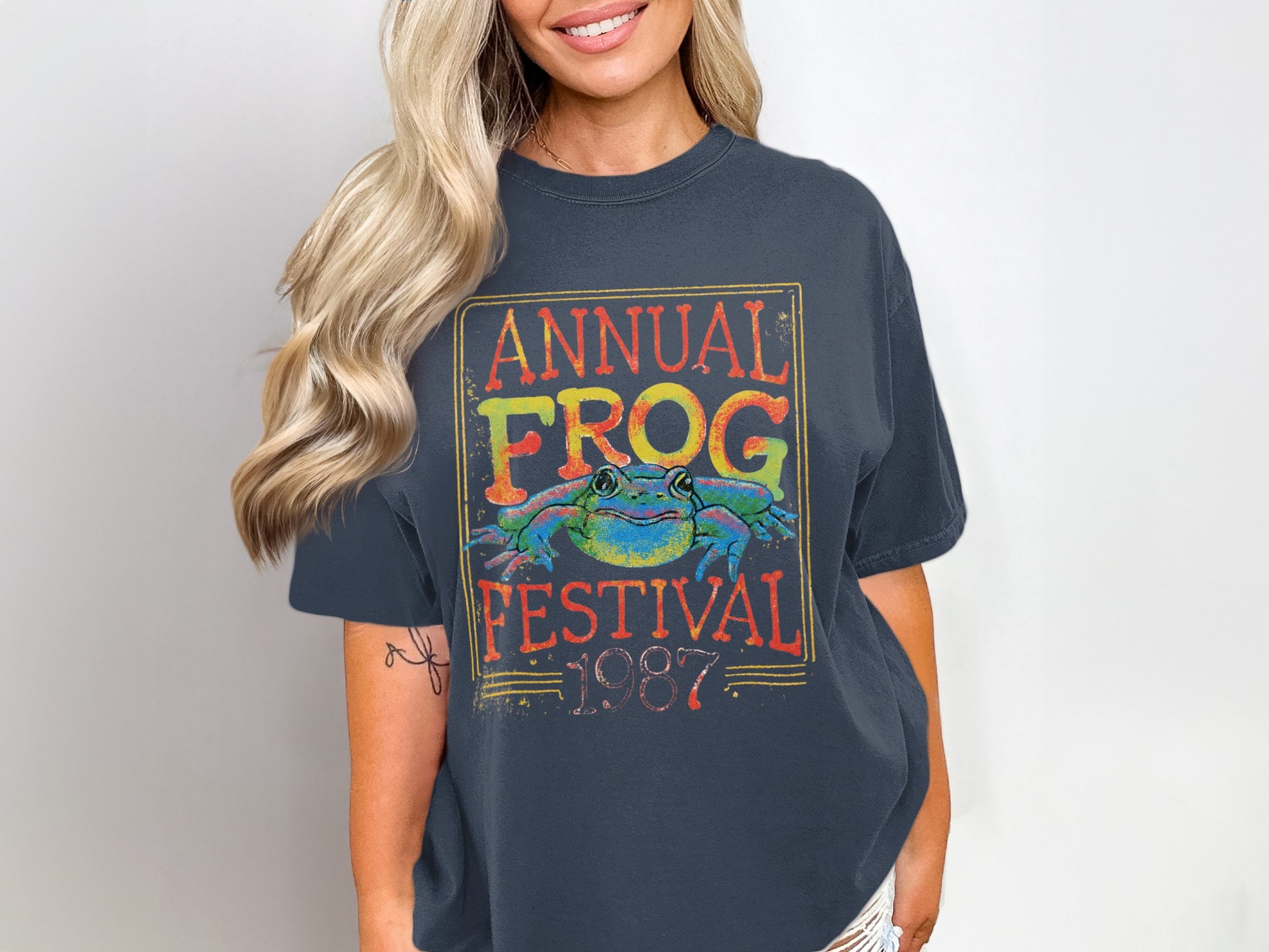 Dark t-shirt with "Annual Frog Festival 1987" and a colorful frog graphic.