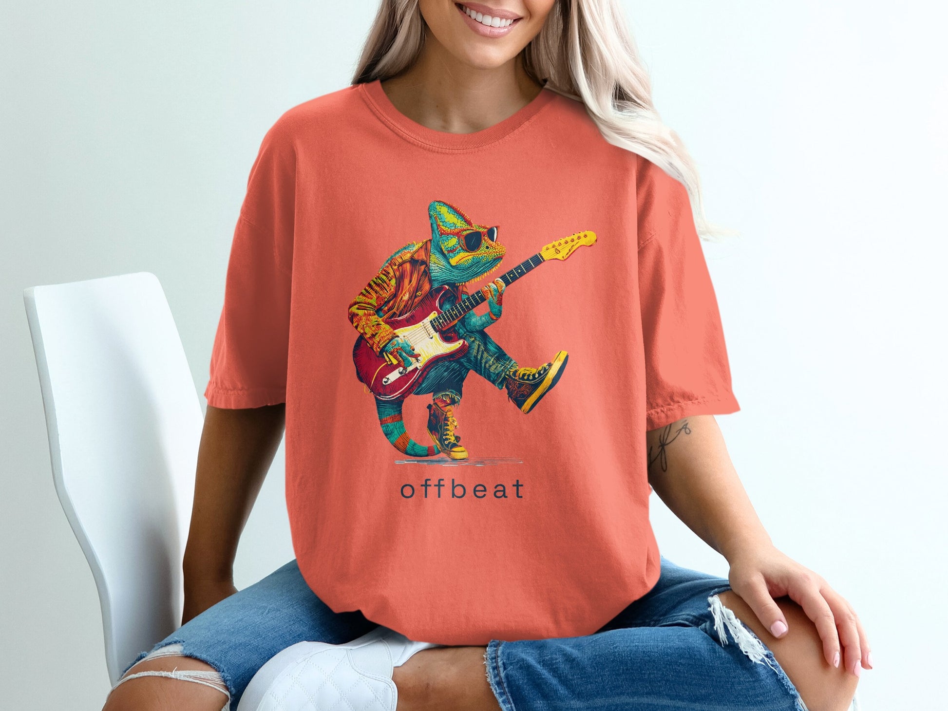 Chameleon wearing sunglasses and a jacket plays a red electric guitar.