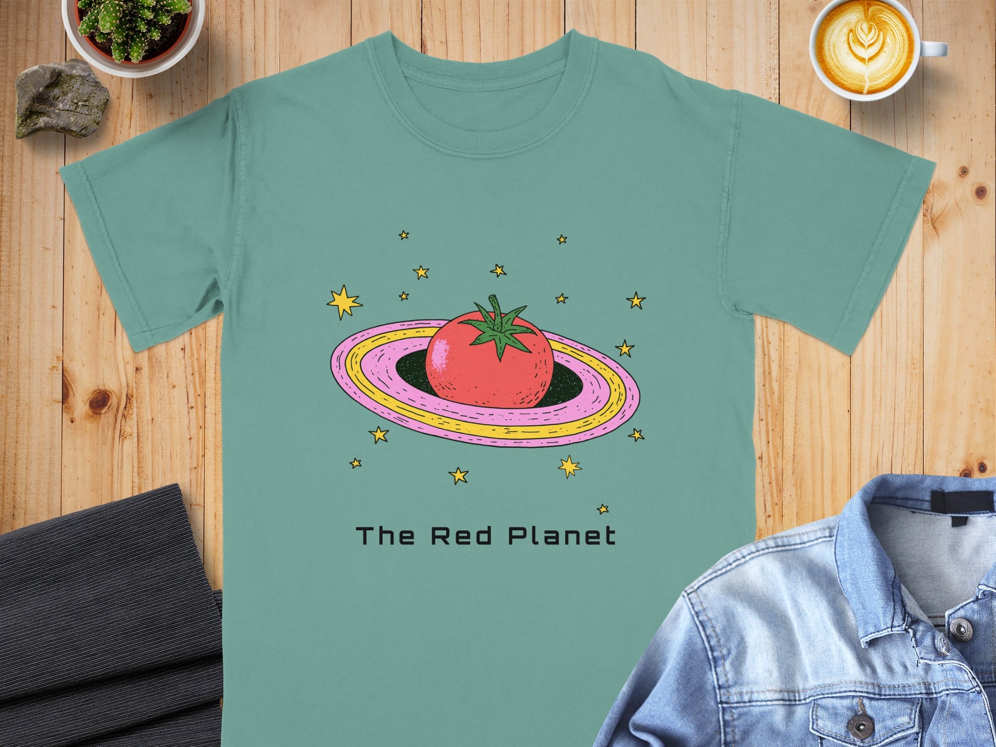 Teal t-shirt with a cartoon tomato on a ringed planet and "The Red Planet" text.
