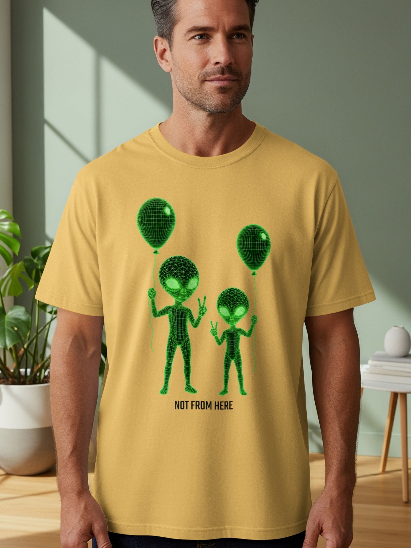 Yellow t-shirt with green alien graphics and balloons, reading "NOT FROM HERE".