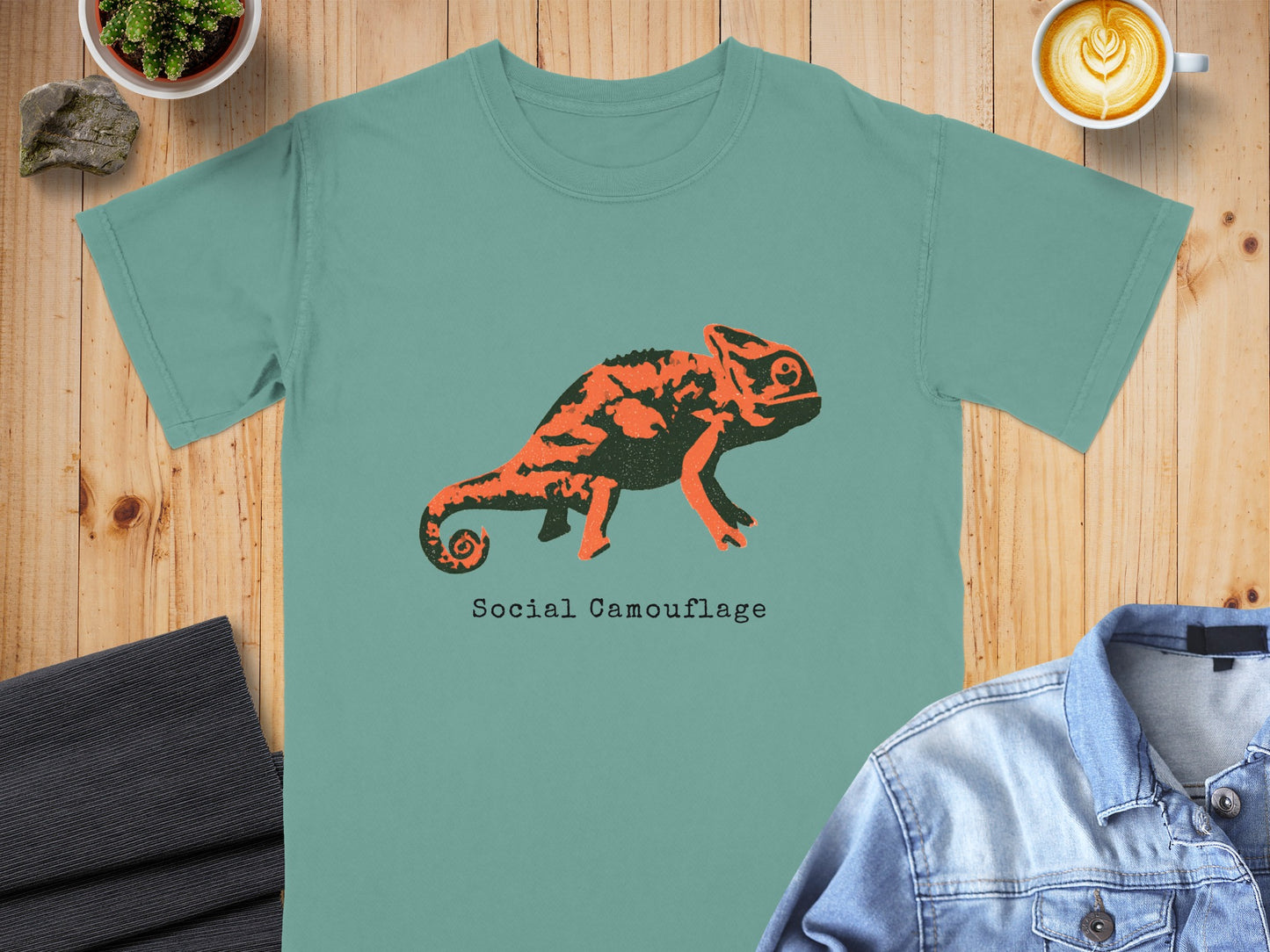 Teal t-shirt with orange chameleon graphic and "Social Camouflage" text.