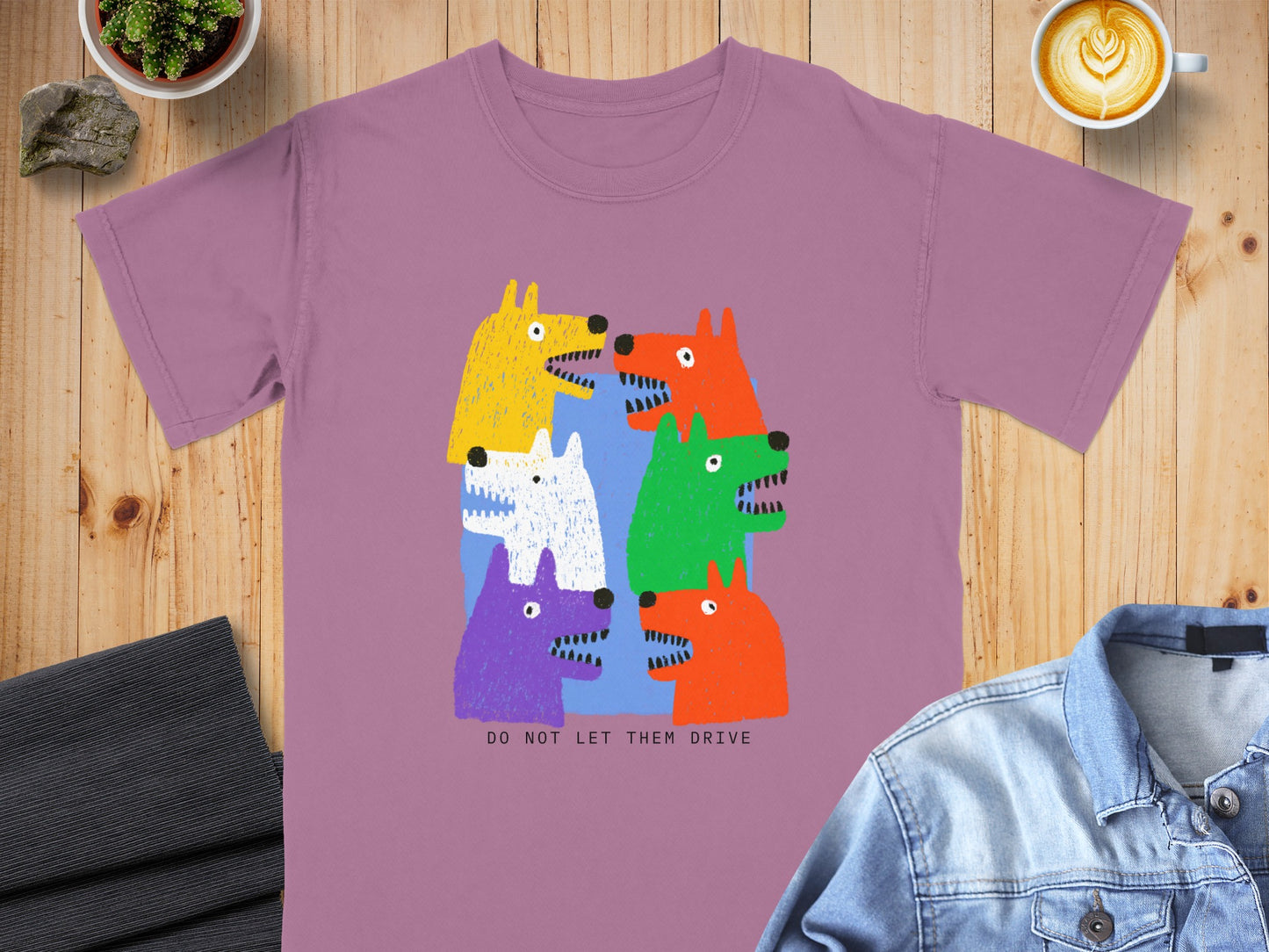 Purple t-shirt with a colorful graphic of six stylized dogs and text that reads "DO NOT LET THEM DRIVE".